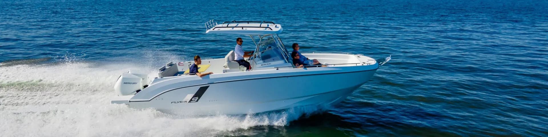 A Beneteau Flyer 9 running at speed, three aboard