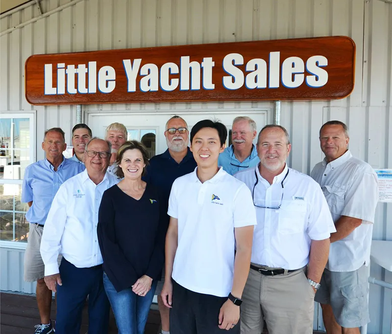 The Little Yacht Sales team in front of their office sign