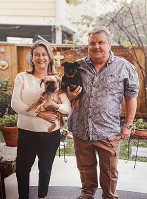 Kent and Liz Little at home, each holding one of their dogs